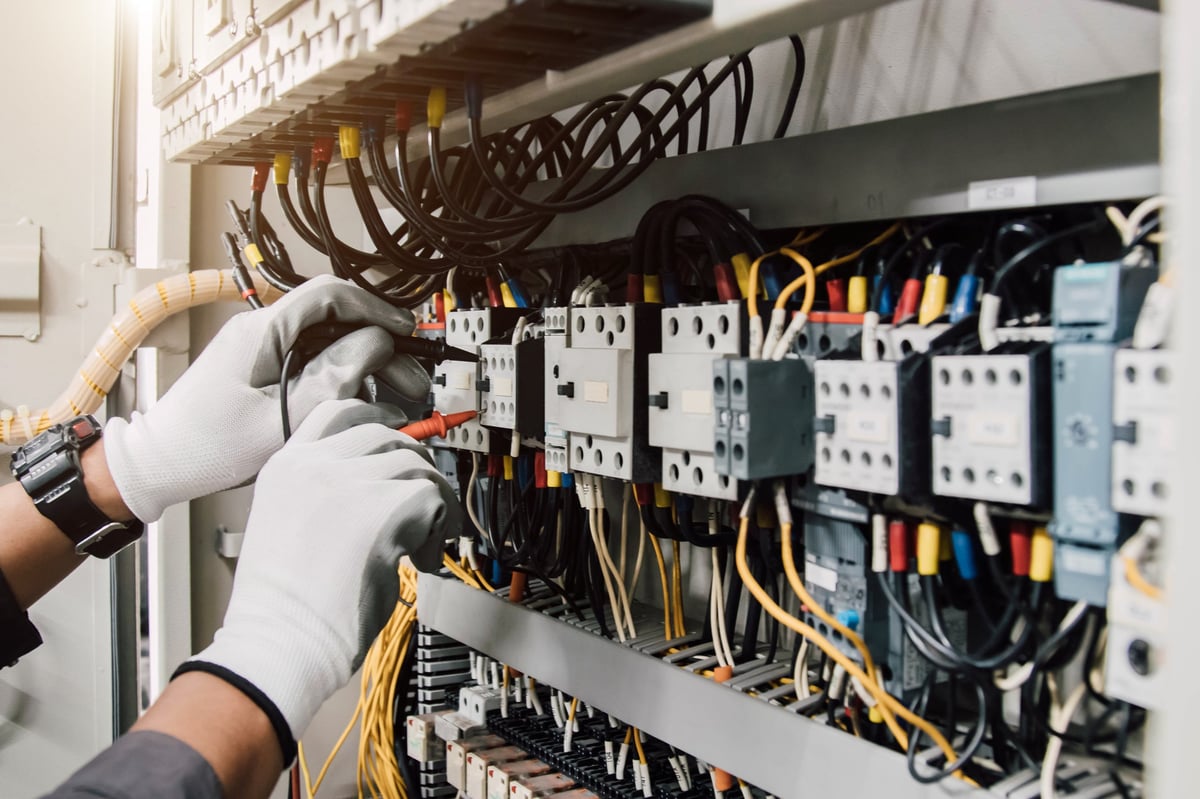 Electrician working on electrical panel in newly constructed home